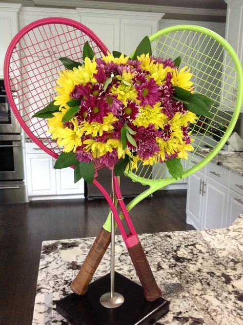 Table centerpiece I made with rackets from Goodwill! Tennis Floral Arrangement, Tennis Wreath, Tennis Centerpieces, Graduation Hats Decorated, Tennis Decorations, Tennis Decor, Event Flower Arrangements, Wedding Flower Arrangements Table, Tennis Cake