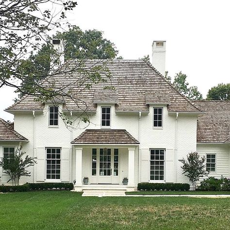 we loved painted brick and this dreamy scene with white painted brick and a cedar roof is pretty perfect 💙 (repost via… Painted White Brick House, White Painted Brick, Roof Shingle Colors, Cedar Shake Roof, Shake Roof, Painted Brick House, Cedar Shake, Cedar Roof, Cedar Shakes