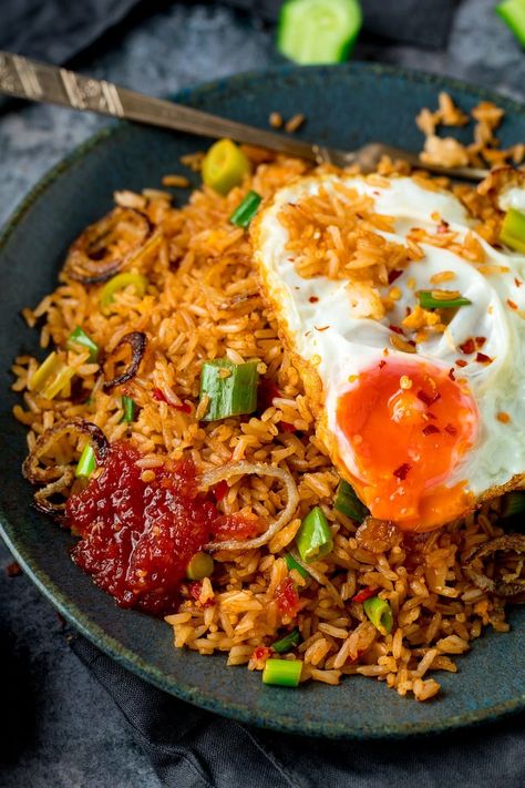 Nasi Goreng is a delicious spicy stir-fried rice. It's more flavourful than regular fried rice with the addition of shrimp paste, fish sauce, tamarind and a few other goodies. Topped with a runny fried egg (those crispy edges are a must!), this classic Asian meal makes a great family dinner. When you're in the mood for street food at home, this is the one to go for. #nasigoreng #Indonesianfood Nasi Goreng Recipe, Tasty Fried Rice, Chinese Fried Rice, Healty Dinner, Spicy Rice, Rice Bowls Recipes, Shrimp Paste, Nasi Lemak, Asian Dishes