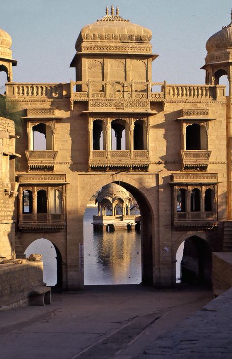 Built in 1156 by King Rawal Jaisal, Jaisalmer Fort dominates the countryside in the far northwestern corner of Rajasthan, near the border of India and Pakistan. The magnificent complex, also known as Sonar Kila ("Golden Fort") for its gleaming golden sandstone walls and buildings, flourished on the east-west caravan route connecting India and Central Asia to the Middle East and North Africa. Merchants built elaborately designed havelis among the numerous palaces, temples, bazaars, and residences Middle Eastern Palace, Indian Buildings, Middle East Architecture, World Monuments, Jaisalmer Fort, India Travel Places, Sandstone Wall, India Architecture, Ancient Indian Architecture