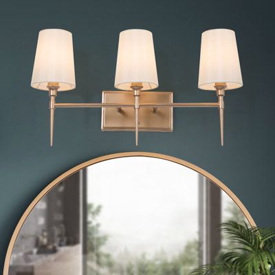 Inject new energy to your bathroom, powder room, or bedroom with this 3-light vanity light. Supported by a rectangular backplate with horizontal arms, this fixture features brass finishes and white fabric shades, which brings modern charm to your cozy home. No matter what style your room is, the simple and classic vanity light is a perfect choice for you. Plus, the dimmer switch and dimmer bulbs (not included) are recommended to satisfy your different vibe needs. | House of Hampton® Amer 3-Light Blue And Pink Bathroom, 90s Home Update, Mirror Sconces, Brass Vanity Light, Vanity Light Bar, Powder Room Decor, Brass Sconces, Transitional Vanity, Arched Mirror