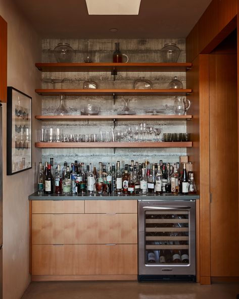 An amply stocked liquor cabinet and under-counter fridge (filled with Baker Lane wines) marks the entrance to the walk-in pantry. Floors throughout the house are concrete with an integrated pigment. Pantry With Fridge, Living Room Bar Ideas, Finished Basement Bars, Pool Bar Design, Wet Bar Basement, Counter Fridge, Alcohol Bar, Bar Space, Bar Unit