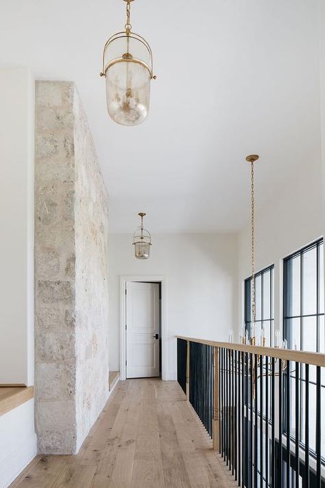 Black Metal Railing, Stone Feature Wall, Staircase Landing, Stone Walls Interior, Kate Marker Interiors, Glass Lanterns, Stone Wall Design, Herringbone Wood Floor, Stone Stairs