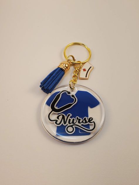 Handmade Acrylic and Resin Keychain  Gold Tone Nurse Design with Scrub Top Nursing Charm and Tassel Several Colors to choose from  Great gift for the special nurse in you life. Great gift for graduation or just as a Thank You  Each keychain is a 2 inches x 2 inches round circle acrylic with permanent vinyl (all waterproof) and sealed with UV resin to ensure durability and scratch resistance  Check out me store for additional designs Epoxy Keychain Ideas, Epoxy Keychains, Handmade Leather Jewelry, Gift For Graduation, Nurse Design, Resin Keychain, Round Circle, Uv Resin, Permanent Vinyl