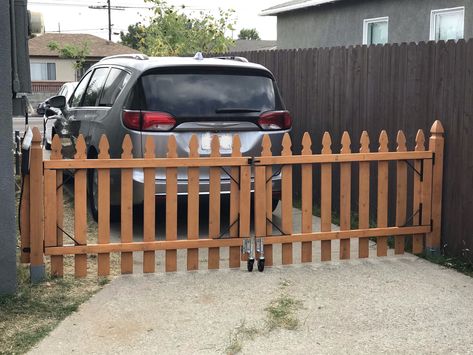 Driveway gate using picket fence panels and casters Pallet Driveway Gate, Build Picket Fence, Picket Fence Driveway Gate, Temporary Gate Ideas, Fence Across Driveway, Diy Driveway Gate Cheap, Driveway Fence Ideas, Diy Driveway Gate, Temporary Fence For Dogs