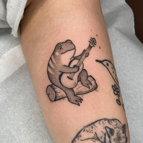 A cutie frog playing guitar 🎶✨ thank you Lotte ! Made at @truelovetattoocollective ✨ Bookings are open for May ! 💛🖤 Frog Playing Guitar Tattoo, Frog Playing Guitar, Portfolio Reference, 12 Tattoos, Frog Tattoo, Branch Tattoo, Frog Tattoos, Guitar Tattoo, Tattoo Portfolio