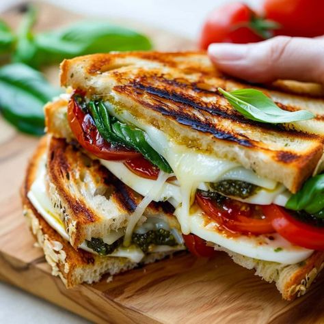 Level up your lunch game with this Caprese grilled cheese sandwich! With tomatoes, basil, pesto, and mozzarella, it's such a refreshing treat. Caprese Grilled Cheese, Pesto And Mozzarella, Buffalo Chicken Grilled Cheese, Grill Cheese, Tomatoes On Toast, Mozzarella Sandwich, Grilled Ham And Cheese, Pesto Cheese, Grill Cheese Sandwich Recipes