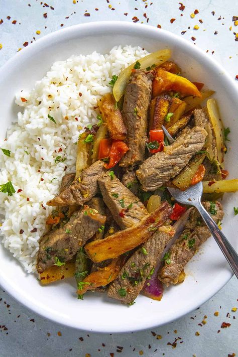 This lomo saltado recipe is a classic beef stir from from Peru with marinated beef strips quickly stir fried with french fries and lots of vegetables. So delicious! Lomo Saltado Recipe, Cajun Fries Recipe, Guisada Recipe, Easy Chickpea Curry, Rellenos Recipe, Gumbo Recipe Sausage, Chili Pepper Recipes, Beef Stir Fry Recipes, Chickpea Curry Recipe