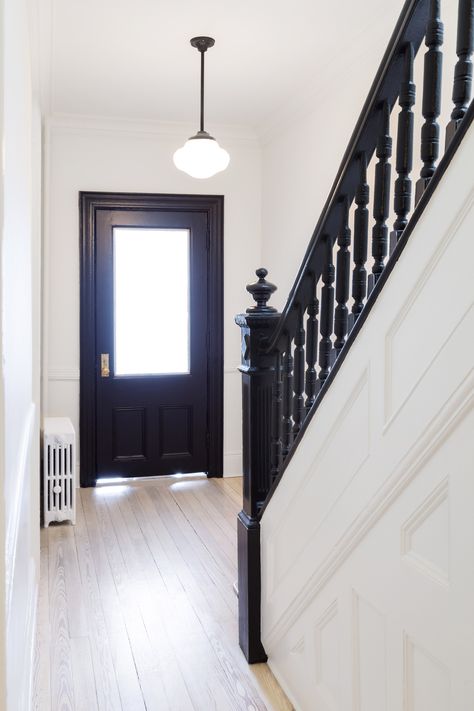 White Arrow renovates Queens rowhouse with navy millwork and modernist furniture Stairs Painted Black, Closed Stairway, Black Entrance, Stairs Painted, Black Staircase, Stairs Room, White Hallway, Black Stairs, Painted Staircases