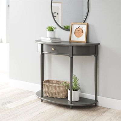 Give your living room or entryway a glow-up with a beautiful new Half-Moon Console Table. The classic elegance of the half-moon top and tapered legs create a vintage yet sophisticated feel perfect for any décor. This half-moon Console Table features a spacious drawer to keep clutter out of sight and a lower shelf for books, photos, or other decorative items to cozy up the room. Made sturdy painted MDF, the Console Table is as durable as it is affordable and assembly is a snap! With the preassemb Small Entry Tables, Shelf For Books, Half Moon Table, Half Moon Console Table, Small Console Table, Console Table With Drawers, Mirrored Console Table, Wood Accent Table, Grey Room