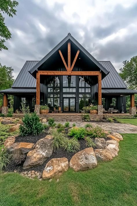 Front view of a barndominium with large glass windows and wooden beams. Saddle up your creativity with simple barndominium ideas that blend rustic charm with modern comforts for a home that’s as practical as it is eye-catching. Farmhouse With Large Windows, Stone House With Wrap Around Porch, Barndominium Built Into Hill, Guest House Barndominium, Vaulted Ceiling Barndominium, Barndominium With Lots Of Windows, Barndominium Back Porch, Barndominium Ideas Interiors Open Floor Plan, Barndominium With Big Windows