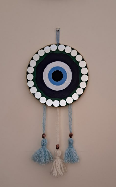 Used a mdf board to make this.Acrylic colors and woollen tassels. Added mirrors to make it eye catchy. Beautiful simple easy💕💕 Mdf Board Mirror Art, Evil Eye Dream Catcher Diy, Creative Craft Ideas Diy Projects, Project Making Ideas, Handmade Creative Wall Decor, Mdf Board Painting Ideas, Clay Art Easy, Evil Eye Diy, Mirror Canvas Art