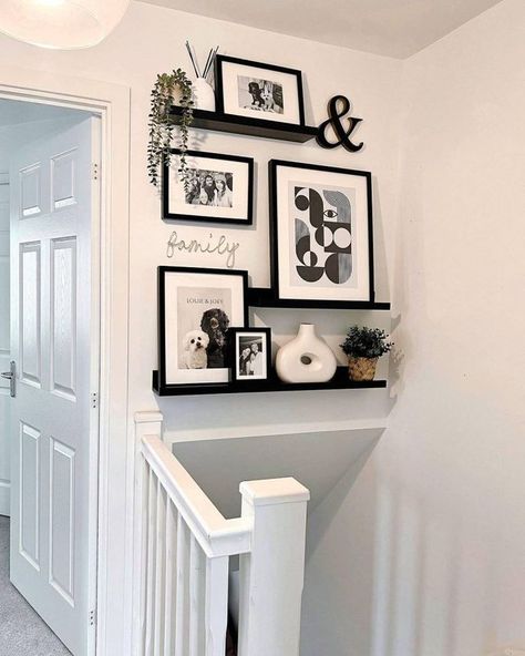 Last on our list is a gallery wall on floating shelves. They’re decked out with a mix of black and white framed artworks and photographs, giving off a modern minimalist vibe. Image credit: INSTAGRAM @OUR_HANBURY_HIDEAWAY Picture Wall Ideas Small Space, Shelves Above Stairs, Wall At Bottom Of Stairs Decor, Small Landing Decor Upstairs, Hall Ways Ideas Entrance Modern, Floating Shelves Gallery Wall, Black And White Wall Ideas, Black And White Frames On Wall, Gallery Wall Ideas With Shelves