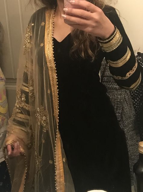 Elegant punjabi suit in black velvet with golden laces on arms and golden embroidered dupatta. Black Velvet Dress With Dupatta, Golden Dupatta Suit, Black Velvet Kurti Design, Suit With Golden Dupatta, Black Velvet Suit Design, Golden Lace Design On Suits, Golden Dupatta Designs, Black Plain Suit With Heavy Dupatta, Black Dupatta Designs Ideas