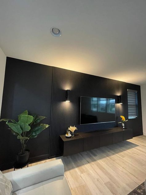 Tv With Paneling, Basement Faux Fireplace, Black Walls Light Wood Floor, Black Accent Wall Entertainment Center, Slat Wall Living Room Ideas, Black Accent Wall Movie Room, 70” Tv Wall, Deep Green Interior Design, High Tv Wall Ideas