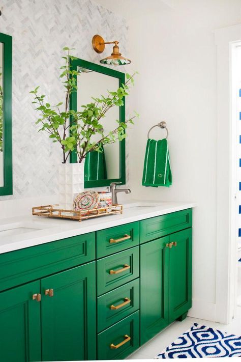 This gorgeous green-and-white bathroom is a preppy dream! Two mirrors and a double vanity make it easy for a pair of people to prepare for their day. Farmhouse-style fixtures light up the space, while a blue-and-white throw rug provides a bright contrast to the kelly green cabinets and accents. Blue And White Rug, Green Homes, Neutral Bathroom, Bad Inspiration, Decor Baie, Green Stuff, Forest Bathing, Modern French, Green Cabinets