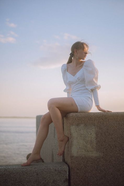 Woman in Dress Sitting on Rock against Blue Sky · Free Stock Photo