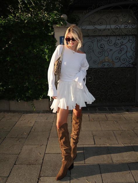 Embrace Western vibes with these 18 casual cowboy boots outfits perfect for fall, winter and beyond! For example, how cute is this chic outfit with a white mini skirt, a white sweater and brown knee-high cowboy boots? 2023 Boots, White Dress Boots, Western Summer Outfits, Western Looks, Style Cowboy Boots, Brown Boots Outfit, Blue Cowboy Boots, Cowboy Boot Outfits, Western Boots Outfit