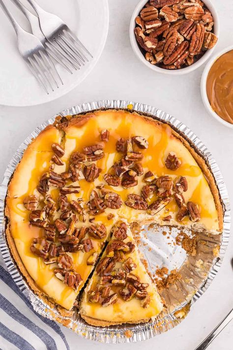 caramel pecan cheesecake with a slice cut out Pecan Caramel Cheesecake, Caramel Pecan Cheesecake Recipes, Pecan Cheesecake Recipes, Caramel Pecan Cheesecake, Simply Stacie, Pecan Cheesecake, Caramel Cheesecake, Cheesecake Filling, Caramel Pecan