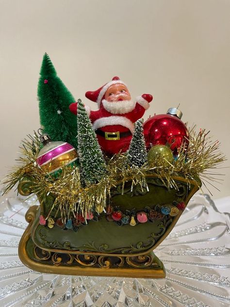 Vintage Christmas Assemblage. Napcoware vintage sleigh, bottle brush tree, vintage dancing Santa , vintage ornaments and vintage tinsel. Christmas craft ideas #christmascraftideas Christmas craft idea #christmascraftidea #christmas #craft #idea merry christmas #merrychristmas 10.446 Bottle Brush Christmas Tree Ornaments, Santa In A Sleigh, Vintage Christmas Garland, Vintage Sleigh, Free Christmas Crafts, Christmas Assemblage, Christmas Crafts Snowman, Vintage Dancing, Christmas Kisses