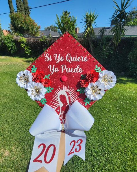 Paper flower, with bow and virgin mary silhouette.grad cap class of 2023 #virginmary #paperflowers #gradcap #graduation Grad Stole Ideas Mexican, Mexico Cap Graduation, Grad Cap Virgin Mary, Caps For Graduation Mexican, Red Cap Decoration, First Generation Graduation Cap Mexican, San Judas Graduation Cap, Catholic Graduation Cap, Karol G Graduation Cap