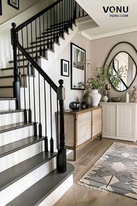 An elegant staircase with a striking black and white contrast, featuring a traditional railing, modern decor, and a stylish console table, creating a sophisticated entrance. Black And White Foyer, Black And White Bannister, White Foyer Entryway, Black And White Staircase, Black Banister, Modern Farmhouse Staircase, White Foyer, Beautiful Houses Exterior, Neutral Bedroom Design