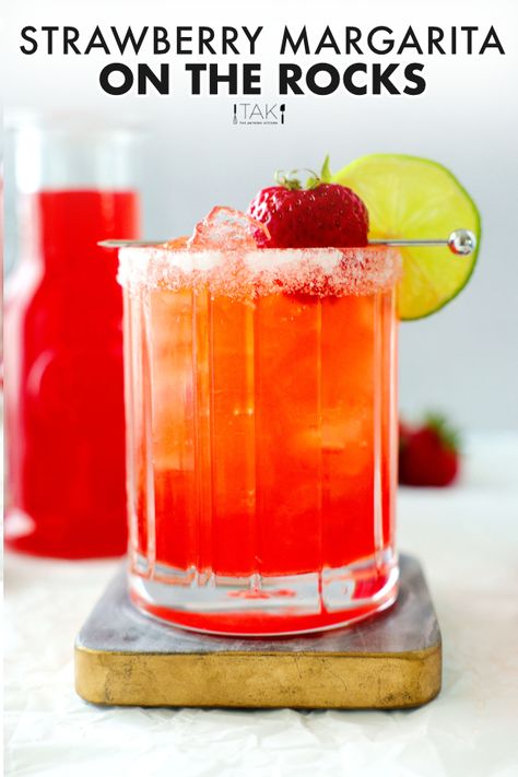 Strawberry margarita on a coaster with strawberry simple syrup in the background. Strawberry Margarita Recipe On The Rocks, Strawberry Margarita On The Rocks, Flavored Margarita Recipes, Strawberry Simple Syrup Recipe, Margaritas On The Rocks, Simple Syrup For Cocktails, Elegant Drinks, Classic Tequila Cocktails, Strawberry Margaritas