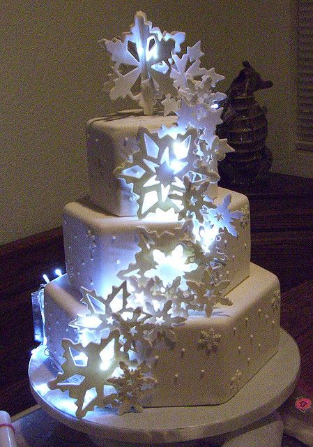 Winter Wonderland Cake! Looks incredible with LED lights behind the snowflakes. Here, use these if you want to re-create the look - LED "ice cubes" made of FDA approved plastic: http://www.flashingblinkylights.com/light-up-products/lighted-ice-cubes.html Wonderland Wedding Cake, Winter Torte, Wonderland Sweet 16, Winter Wonderland Cake, Snowflake Cake, Winter Wedding Cake, Winter Cake, Winter Wonderland Wedding, Wedding Winter