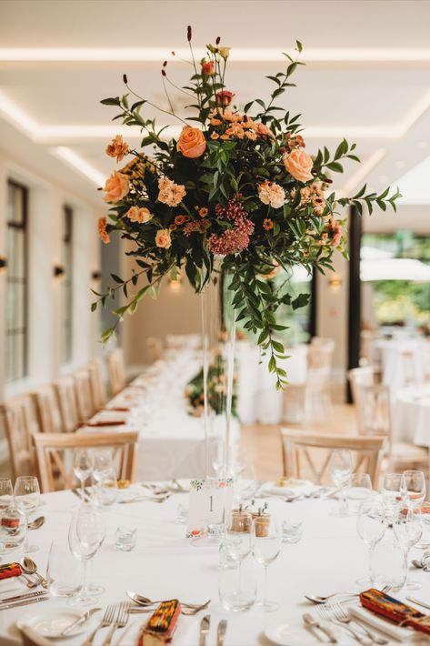 Tall table-centres bring so much drama and wow-factor to your wedding reception. We have a range of tall vases and metal stands that lift the florals well above your guests heads so they can chat easily to each other across the table. Photo by Rachel Jane Photography. Tall Glass Vase Arrangements, High And Low Table Centerpieces, Wedding Table Decorations Orange, October Wedding Centerpieces Table Decor, Tall Flower Arrangements Wedding, September Wedding Centerpieces, Tall Glass Vase Centerpiece, Tall Centerpiece Wedding, Tall Vase Flower Arrangements