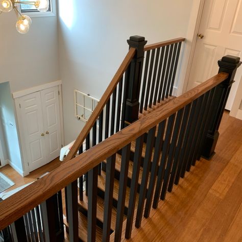 Oak stairs stained with Minmax English Chestnut with off-black wooden balusters and post. Black And Wood Steps, Black And Wood Banisters And Railings, Wood Railing With Black Spindles, Black And Brown Stair Railing, Black And Wood Bannister, Black Wooden Railing Stairs, Oak Stair Railing Makeover, Oak Banister With Black Spindles, Stairs Black And Wood