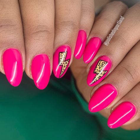 Eight almond shaped nails painted neon pink with a mustard yellow lightning bolt with cheetah print in the middle on the Ring fingers. Lightening Bolt Nails Acrylic, Lightning Bolt Nail Design, Nails With Lightning Bolt, Pink Nails With Cheetah Print, Hot Pink Nails With Lightning Bolt, Pink And Cheetah Nails, Pink And Orange Leopard Nails, Nails With Cheetah Print, Neon Leopard Print Nails