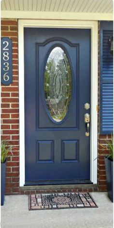 Warning: You need some serious skills to pull this transformation off. These homeowners didn't just add a coat of paint — they replaced the entire door for a navy blue style with a glass window center. See more at The Gardening Cook »    - HouseBeautiful.com Repainting Doors, Navy Front Door, Blue Front Door, Front Door Makeover, Door Paint, Front Door Paint Colors, Brick Decor, Door Paint Colors, Red Brick House