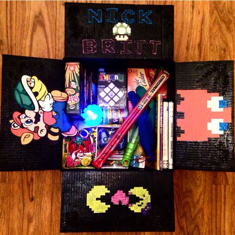 Arcade Game theme care package for my military boyfriend!!! Or the anti-boredom box as I like to call it! I've included a lot of puzzle type items to entertain him, silly prank items, slinky, rubix cube, giant bubbles, snacks & toiletries. #usmarineboyfriend #arcadegame #videogame #mario #pacman #carepackage Care Package Decorating, Military Boyfriend, Boyfriend 21st Birthday, Deployment Packages, Deployment Ideas, Happy Birthday Boyfriend, Military Box, Gifts For Him Birthday, Box Cadeau