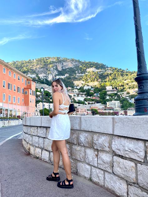 Girl with pink hair in Villefranche-sur-mer wearing a white backless mini denim sundress and dr martens strappy platform sandals Sandles Outfit, How To Style Dr Martens, Doc Sandals, Styling Dr Martens, Martens Sandals, Dr Martens Sandals, White Doc Martens, White Sundress, Euro Summer