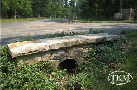 The color tone and size of the natural stone give a solid and mature look to this culvert. Colvert Landscaping, Culvert Driveway, Stone Culvert, Ditch Landscaping, Driveway Culvert, Wall Gardens, Driveway Entrance Landscaping, Drainage Ditch, Driveway Ideas