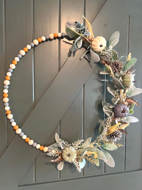 Wood bead hoop designed with a simple modern style. With natural and rustic colored wood beads, featuring beautiful lambs ear greenery along with fall foliage and trendy pumpkin decor. This wreath is the perfect accent piece for any room or an all-occasion fall front door greeting! Beaded Hoop Wreath, Fall Decor Boho, Beaded Wreath, Neutral Fall Decor, Fall Front Door, Autumn Magic, Festive Wreath, Lambs Ear, Pumpkin Decor