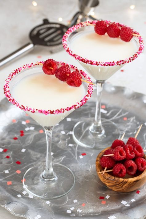 Two white chocolate cocktails in martini glasses and garnished with raspberries. Valentines Day Pitcher Drink, Vday Drinks Cocktail Recipes, Valentines Martini Drink Recipes, Valentines Theme Cocktails, Valentines Day Martini, Valentine's Day Cocktails, Valentine’s Day Martinis, February Esthetic, Vday Cocktails