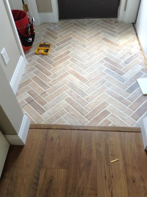 White Glazed Terracotta Tile, Herringbone Tile Entry, Cozy Tile Floors, Brick Slip Herringbone Fireplace, Entrance Ceramic Floor, Herringbone Tile Foyer, Herringbone Brick Floor Bathroom, Kitchen Living Room Flooring Transition, Small Entry Tile