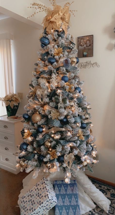 Blue/gold decorated Christmas tree . Blue and gold decor Flocked Christmas Trees Decorated Blue And Gold, White Blue And Gold Christmas Tree, Christmas Tree Themes Colors Blue And Silver, Blue Flocked Tree, Blue White Silver Gold Christmas Tree, Blue Gold And White Christmas Decor, Blue And Rose Gold Christmas Decor, Blue Ornaments On Christmas Tree, Blue Brown And Gold Christmas Tree