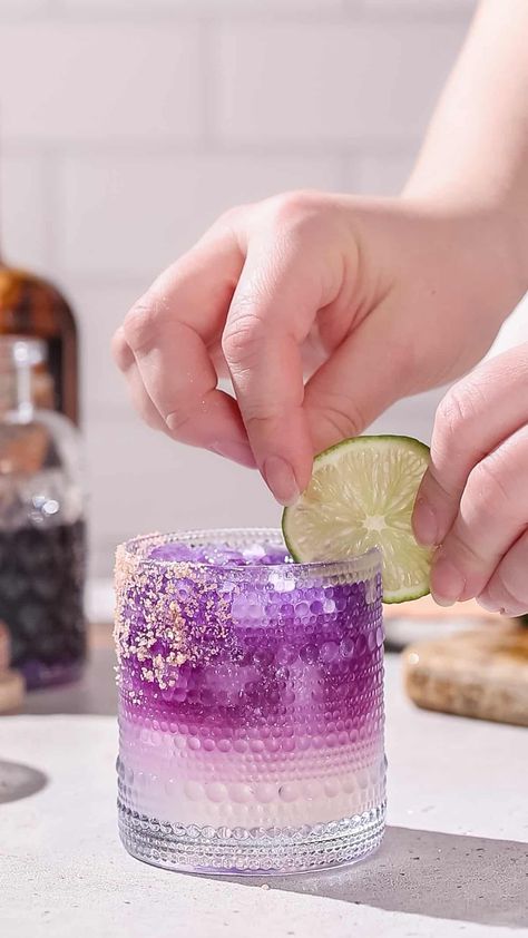 The Galaxy Margarita is as tasty as it is beautiful! Tequila that's naturally colored by butterfly pea flowers is layered on top of a Cointreau and lime base. Edible glitter takes it to the next level! It is a fun galactic spin on a classic margarita. This is the perfect margarita recipe for a girls night, bachelorette or just a night of stargazing! Perfect Margarita Recipe, Pink Gin Cocktails, Classic Tequila Cocktails, The Perfect Margarita, Prickly Pear Margarita, Butterfly Pea Flowers, Tequila Recipe, Layered Drinks, Perfect Margarita