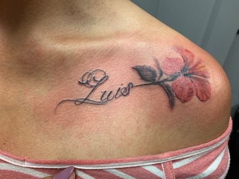 Elegant script tattoo with flower near collarbone with the name “Luis”. Name Collarbone Tattoo, Collar Bone Name Tattoos For Women, Elegant Name Tattoos, Luis Name Tattoo, Lily Tattoo With Name, Collar Bone Tattoo Name, Collar Bone Name Tattoo, Collarbone Name Tattoo, Under Collar Bone Tattoos