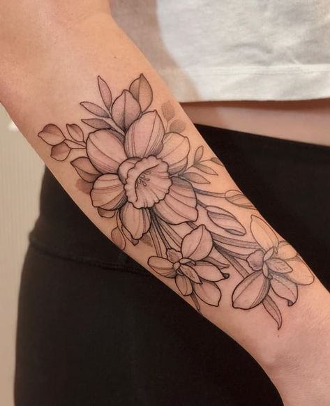 Daffodil Tattoos: Meanings, Tattoo Designs & Ideas Americana Floral Tattoo, Buttflies Tattoo On Arm, Narcissus Flower Tattoo With Butterfly, Daffodil Tattoo Outline, Colored Daffodil Tattoo, Daphadil Tattoo, Butterfly Back Of Arm Tattoo, March Birth Flower Tattoo Daffodils, Tattoos Daffodil