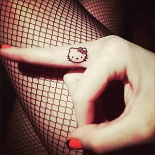 If you’re a fan of small tattoos, this dainty Hello Kitty will do the trick. | 25 Irresistibly Cute Sanrio Tattoos Tattoo Hello Kitty, Katy Perry Tattoos, Cool Finger Tattoos, Hello Kitty Tattoo, Kitty Tattoos, Tiny Finger Tattoos, Kitty Tattoo, Cute Finger Tattoos, Uv Tattoo