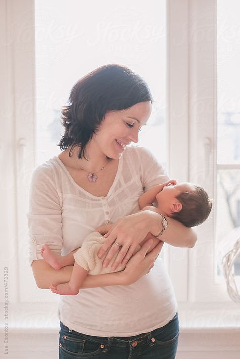 Happy mother holding her newborn baby in her arms looking at him and smiling by LeaCsontos | Stocksy United Holding In Arms Reference, Cradling In Arms Drawing, Baby Poses Reference, Holding Baby Poses Drawing, Arms Holding Something Reference, Mother And Child Reference, Person Holding Baby Drawing Reference, Holding Child Reference, Holding A Child Reference Poses