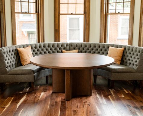 Banquettes have been growing in popularity and it's easy to see why. Their versatility makes banquettes a perfect fit for both cozy residential nooks and stylish commercial spaces.  This curved banquette that we recently built for our friends at CRI Designs features exposed legs and pulled tufting that adds to the elevated, naturally lit dining area. Dining Room Table With Couch Seating, Curved Settee Dining, Curved Dining Banquette, Banquette With Round Table, Round Banquette, Banquette Seating Dining Room, Curved Banquette Seating, Table Banquette, Curved Banquette