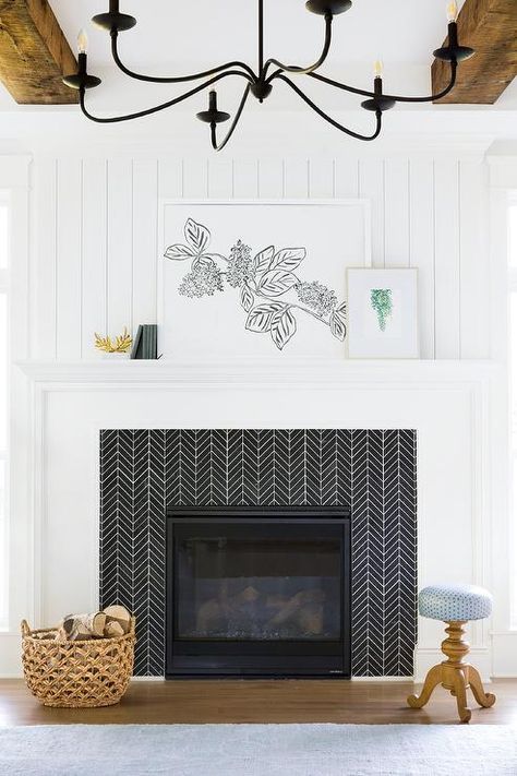 Black chevron fireplace surround tiles are contrasted with white grout and a white mantel topped with art placed against a white shiplap wall. Salons Cottage, Remodel Fireplace, White Mantel, Серая Кухня, Fireplace Tile Surround, White Shiplap Wall, Shiplap Fireplace, Farmhouse Fireplace, White Shiplap