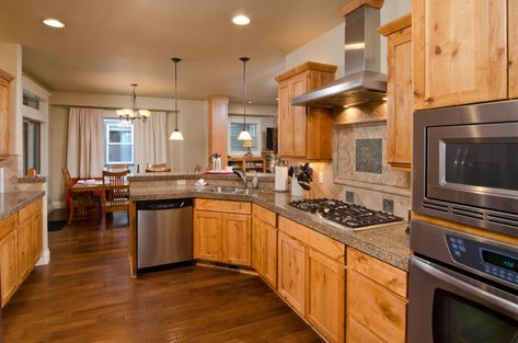 Kitchen with wood floor, oak cabinets, stove, hood, and recessed lights Honey Oak Cabinets With Brass Hardware, Vinyl Plank Flooring With Honey Oak Trim, Hardwood Floors With Oak Cabinets, Early American Stain On Oak Cabinets, Wood Floors With Honey Oak Cabinets, Honey Oak Cabinets With Dark Wood Floors, Honey Oak Cabinet Kitchen Ideas, Oak Cabinets With Dark Floors, What Color Floor With Honey Oak Cabinets