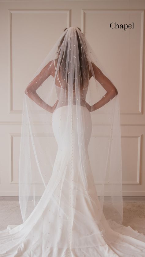 The Hailey Veil is a true statement piece that’s both modern and chic. This veil is dripping with countless pearls, giving the illusion of floating pearl drops. The pearls on this veil are securely studded onto the tulle and are steamer friendly. The Hailey Veil has raw edges to seamlessly drape over the train of your dress. Secured with a heavy-duty silver comb, you can’t go wrong with this stylish and flirty veil. Details: Tulle Color: Bright white, light ivory, creamy ivory. Please view our t Pearl Bridal Hair With Veil, Bride Veil With Hair Down, Veils Bridal 2023, Bridal Veil Pearls, Veils Bridal The Wedding Veil Shop, Plain Wedding Dress With Veil, Long Pearl Veil, Wedding Hair Pearls Veil, Long Veil With Pearls