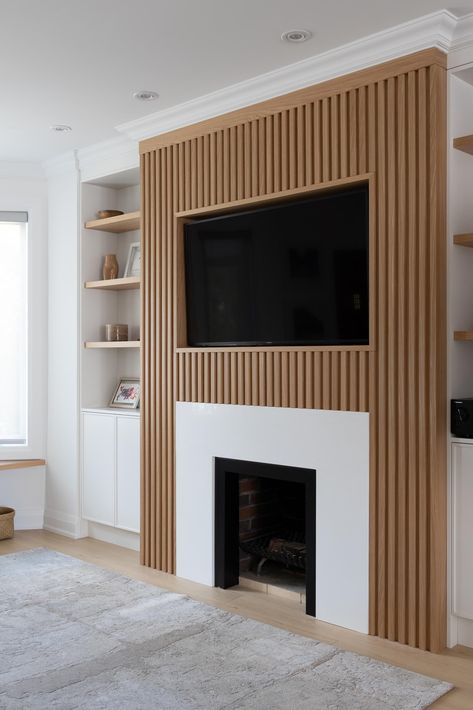 This living room wall has a Scandinavian-inspired design that includes a wood slatted wall that draws the eye, adds a sense of depth, and surrounds the television and fireplace. Slat Wall Ideas Living Room, Slat Wall Ideas, Wall Ideas Living Room, Living Room Wall Designs, Wood Slat Wall, Wood Accent Wall, Ideas Living Room, Home Fireplace, Slat Wall