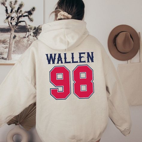 🤠98 Braves Wallen Hoodie🤠  This hoodie is manufactured to a high quality and is made using an air-jet spun yarn for a softer feel and no pill. With its 50% Cotton, 50% polyester pre-shrunk material, this hooded sweatshirt is hard-wearing and easy to wash and dry making it perfect for colder weather. *DO NOT wash above 30 Degrees *DO NOT tumble Dry *DO NOT iron directly onto graphics -Air-jet spun yarn for softer feel -Classic fit, pre shrunk material -Front kangaroo pouch pocket -Ribbed cuffs Wallen Crewneck, Morgan Wallen Hoodie Ideas, Morgan Wallen 98 Braves Shirt, Morgan Wallen Apparel, Morgan Wallen Sweatshirts & Hoodies, 98 Braves, Country And Western, Flare Jeans Outfit, Diy Sweatshirt